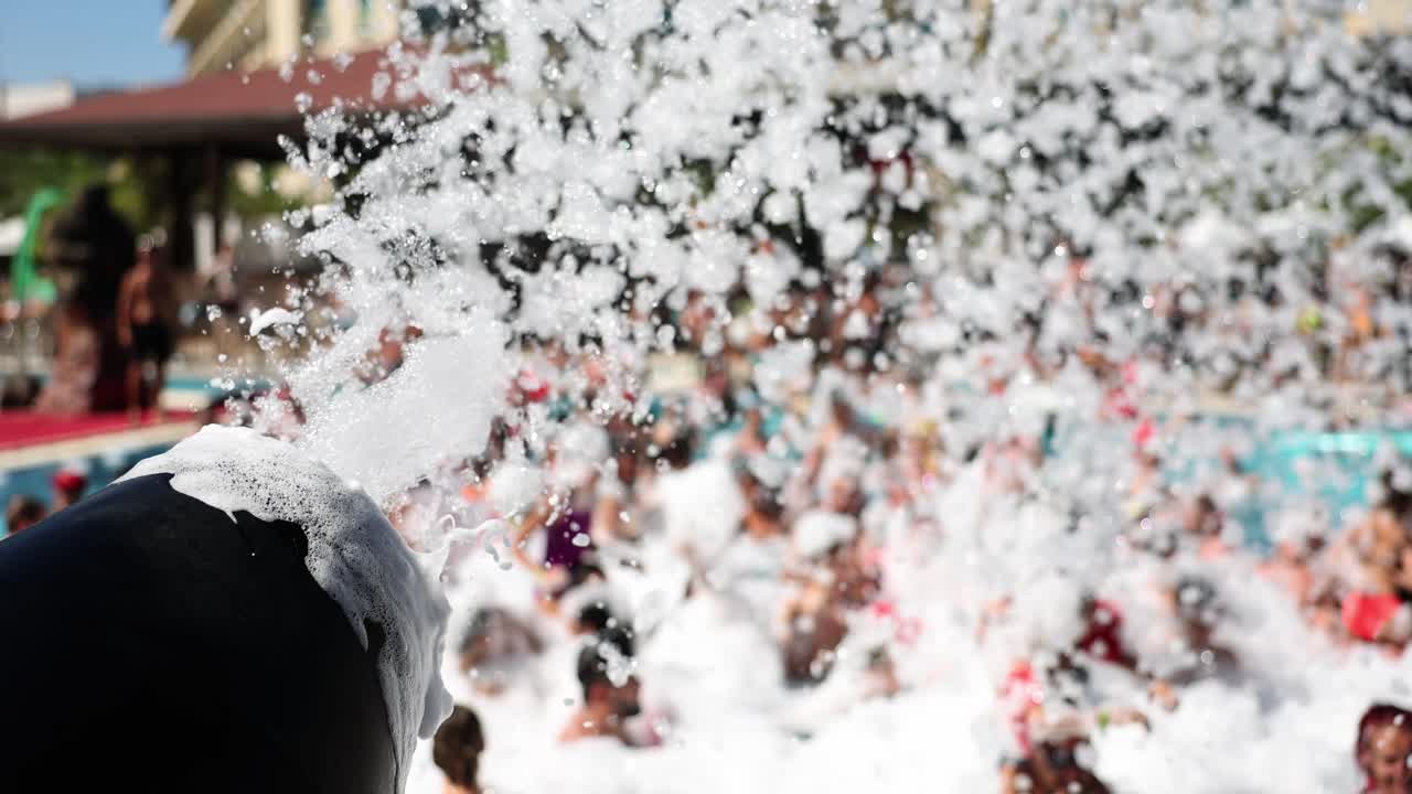 Crowd Enjoying a Lively Foam Party at a Resort Pool
