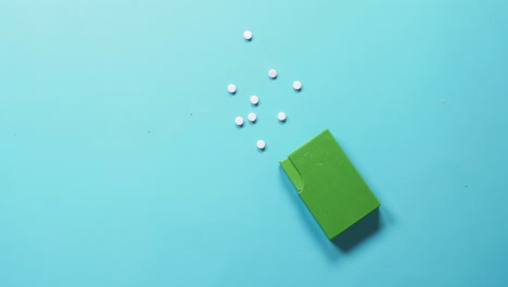 green pill container with loose pills