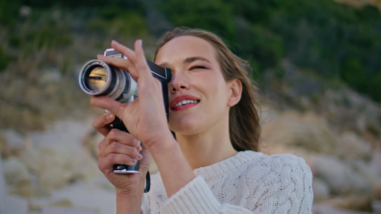 Woman capturing evening nature on retro camera closeup. Happy lady filming