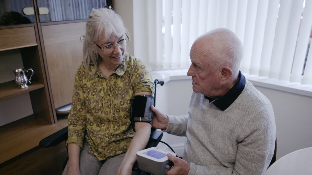 Elderly couple checking blood pressure at home