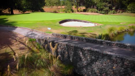 vivid green fairway at international golf course with bunker and river, no people