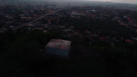 Drone orbits Eyelele Lake hilltop view with low sunlight and forested landscape