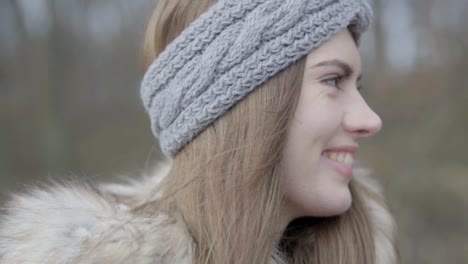 Close-up-view-of-girl's-face-smiling-in-the-forest,-SLOMO