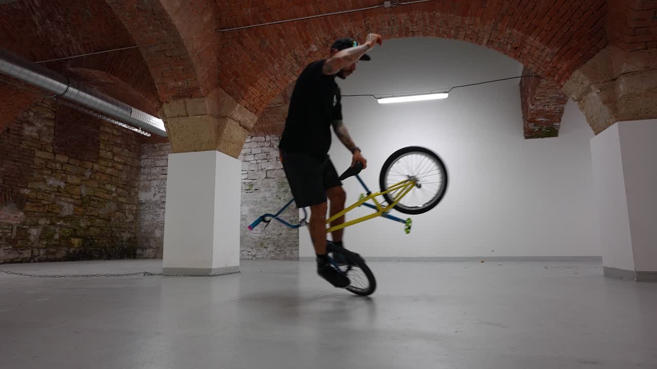 Wide shot of a Bike BMX rider doing tricks on flat ground - gimbal