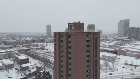 aerial view of minneapolis, minnesota, showcasing a snow-covered cityscape with high-rise buildings, urban streets, and winter scenery.