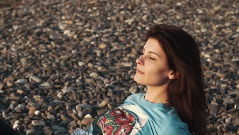 mujer relajándose en una playa de guijarros