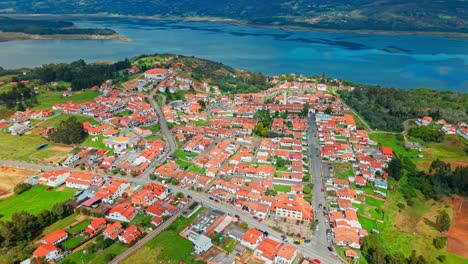 aerial establishing fly above red tile rooftops of colonial houses from guatavita, colombia, natural reservoir landscape
