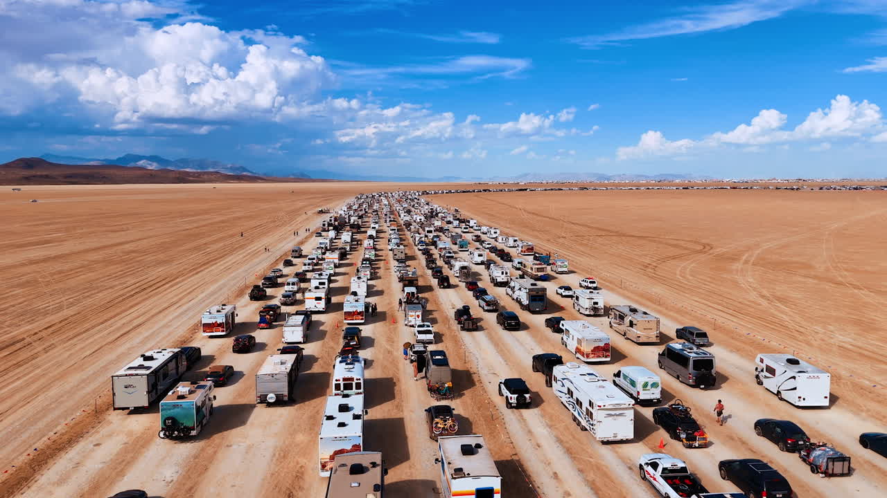 Nevada, USA, 14 August 2025: Traffic of cars and RVs entering the Burning Man festival in Nevada desert. Rows of cars and camper vans line up on the dusty road to Burning Man