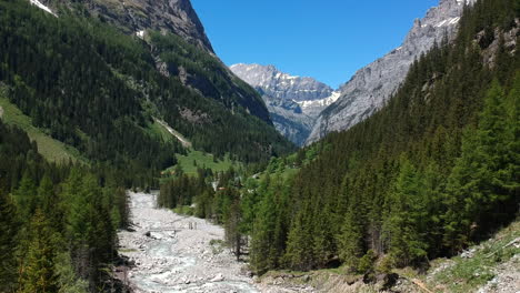 drone flight through a valley in the swiss alps, flanked by majestic mountains