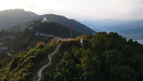 Volando-Hacia-El-Mirador-De-La-Montaña-En-Pokhara,-Nepal,-Con-Vista-A-La-Pagoda-De-La-Paz-Mundial-En-La-Distancia