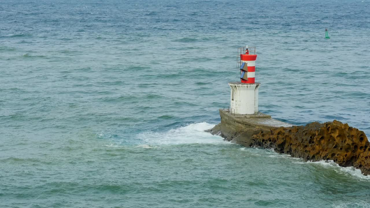 Tranquil waters at Faro de Puntas, lighthouse and rugged Basque coast scenery, serene static view of green ocean