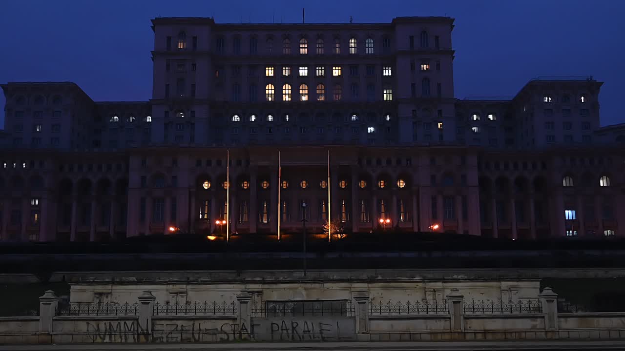 Bucharest, Romania - January 10, 2020: Cars moving in front of the Palace of Parliament building in the evening