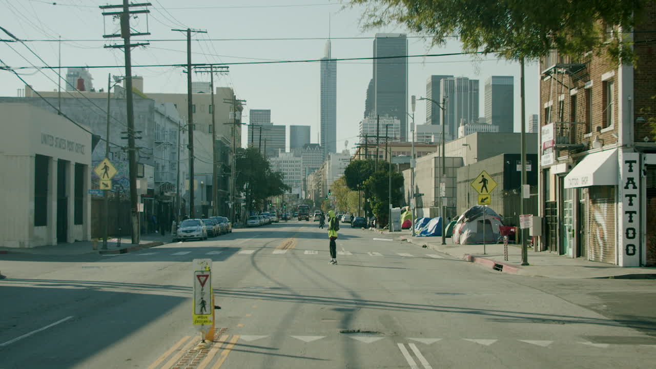 Urban Street Scene with a Person Walking and Downtown Skyline
