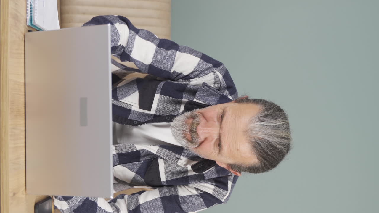 Vertical video of Old man sending wrong mail on laptop. Can't get mail back.