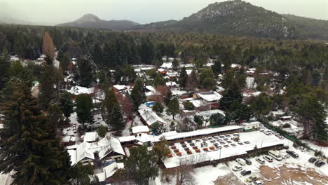drone view picturesque snowy mountain village in bariloche, surrounded by forests and hills, argentina