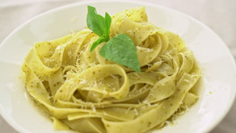 pesto fettuccine pasta with parmesan cheese on top - italian food style