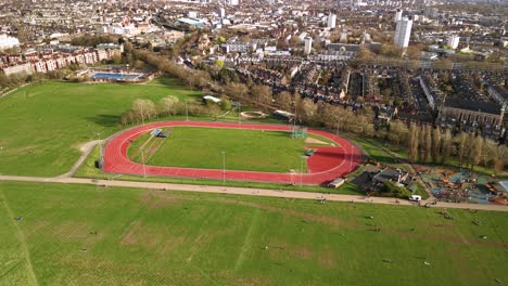 aerial view flying over parliament hill athletic running track oval sporting loop landmark in london