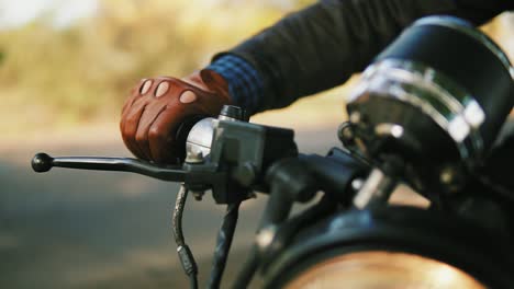 Close Up view of a man&#039;s hand in brown leather mitts starting the engine. Slow Motion shot