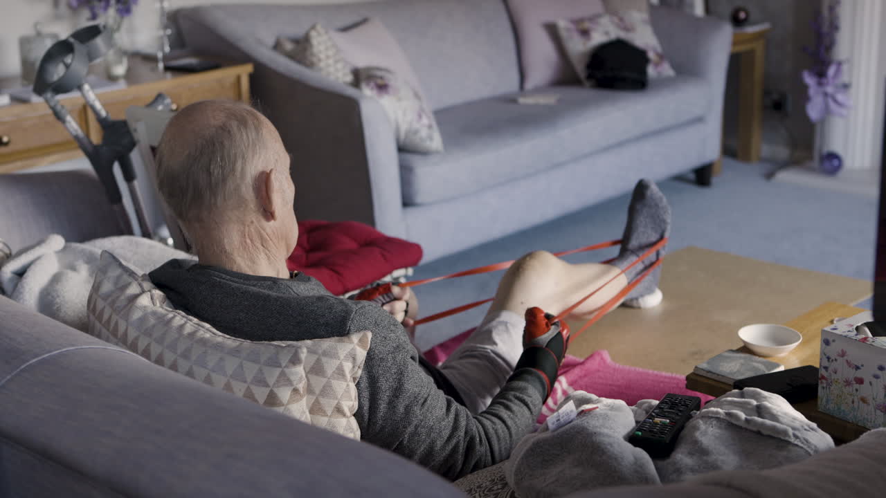 Man exercising with resistance band in living room