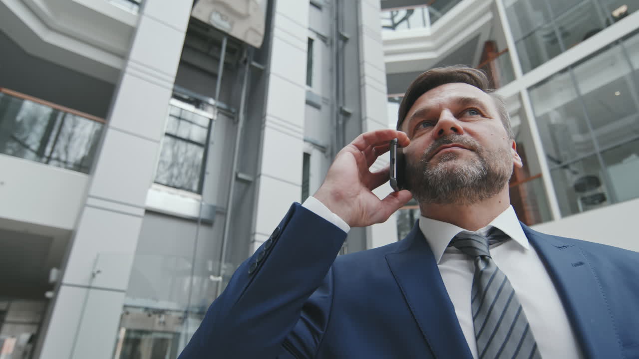 Imprenditore maturo che parla al telefono
