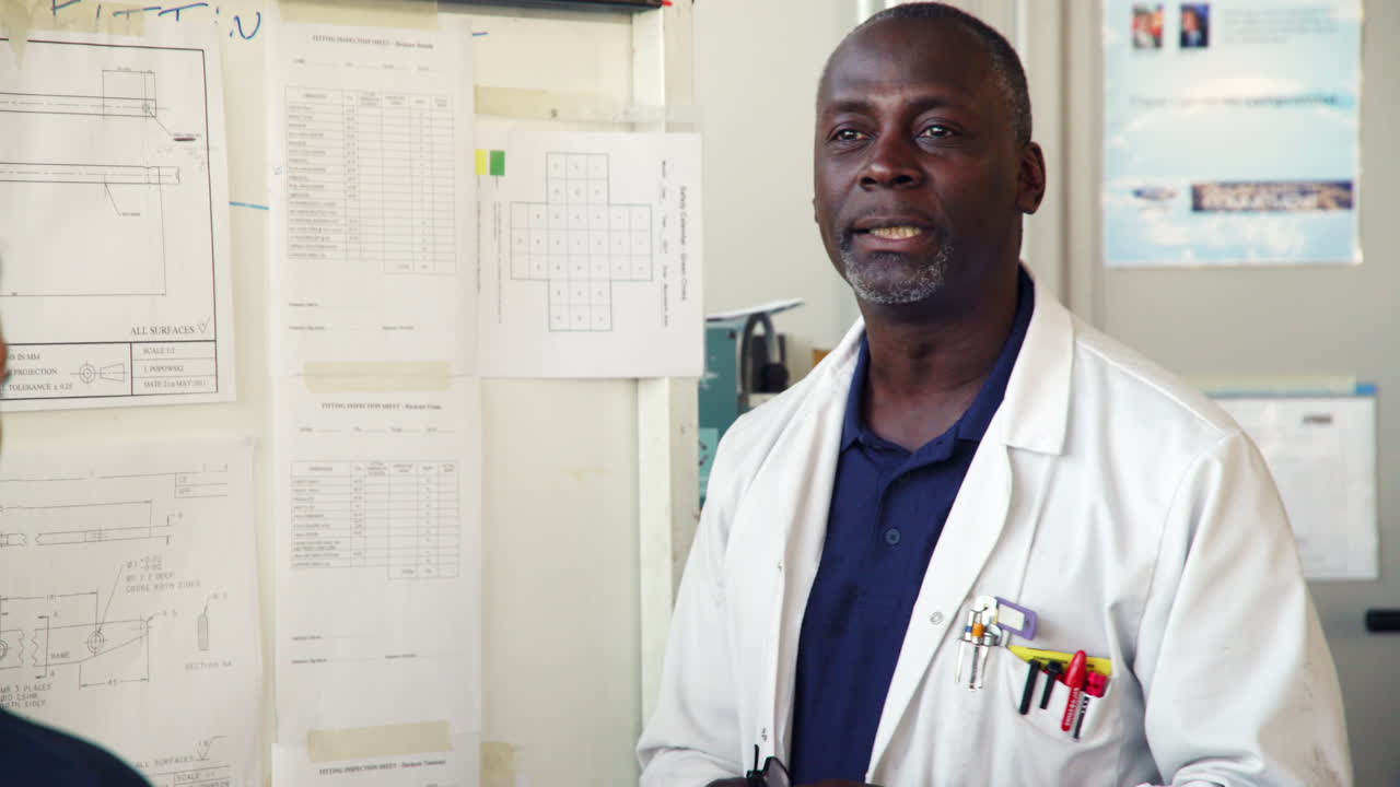 tutor discutiendo dibujos técnicos con ingenieros aprendices