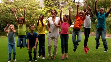 Hübsche-Lehrerin-Springt-Mit-Jungen-Schülern-Vor-Der-Schule-Auf