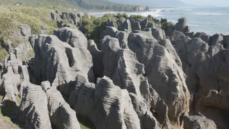 view of rock formations and ocean on a sunny summer day at punakaki pancake rocks, west coast, new zealand.