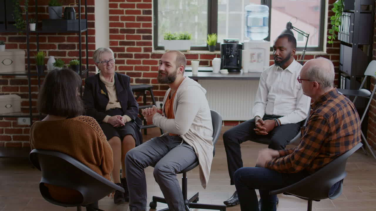 Man doing handshake with therapist and people after sharing addiction progress at aa meeting