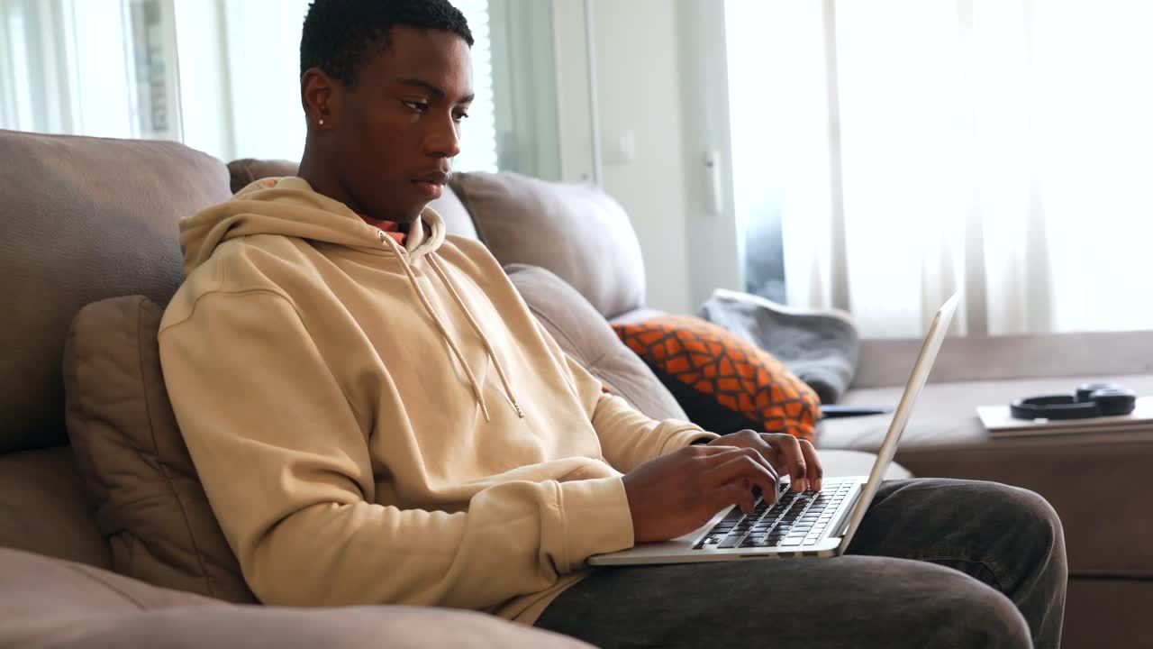 Man sitting on a couch using a laptop