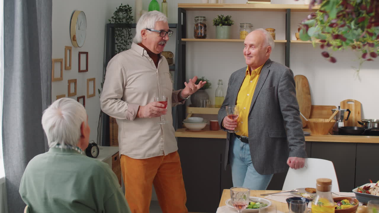 Hombres mayores conversando con vino junto a la mesa de la cena
