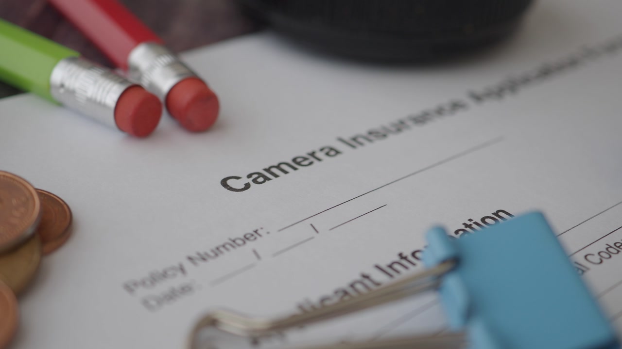 Close-up of Camera Insurance Application Form and Office Supplies