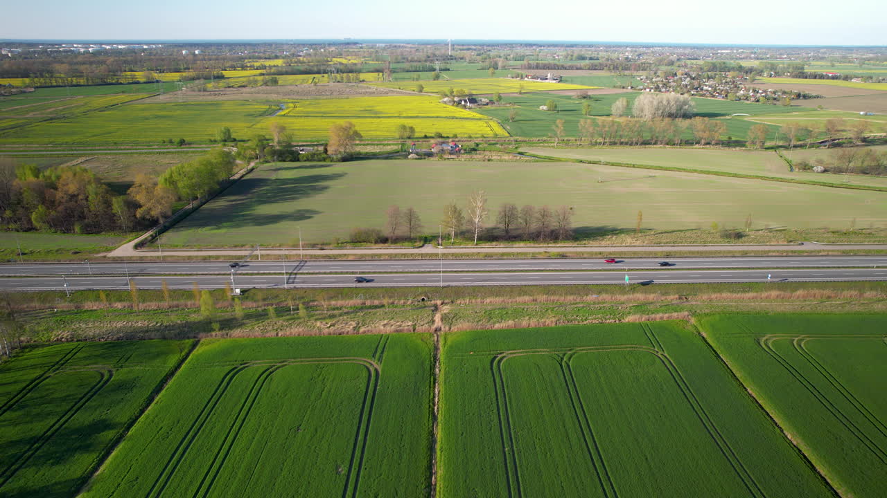 여름에 농경지로 둘러싸인 폴란드의 시골 도로에서 교통을 설정하는 항공 촬영