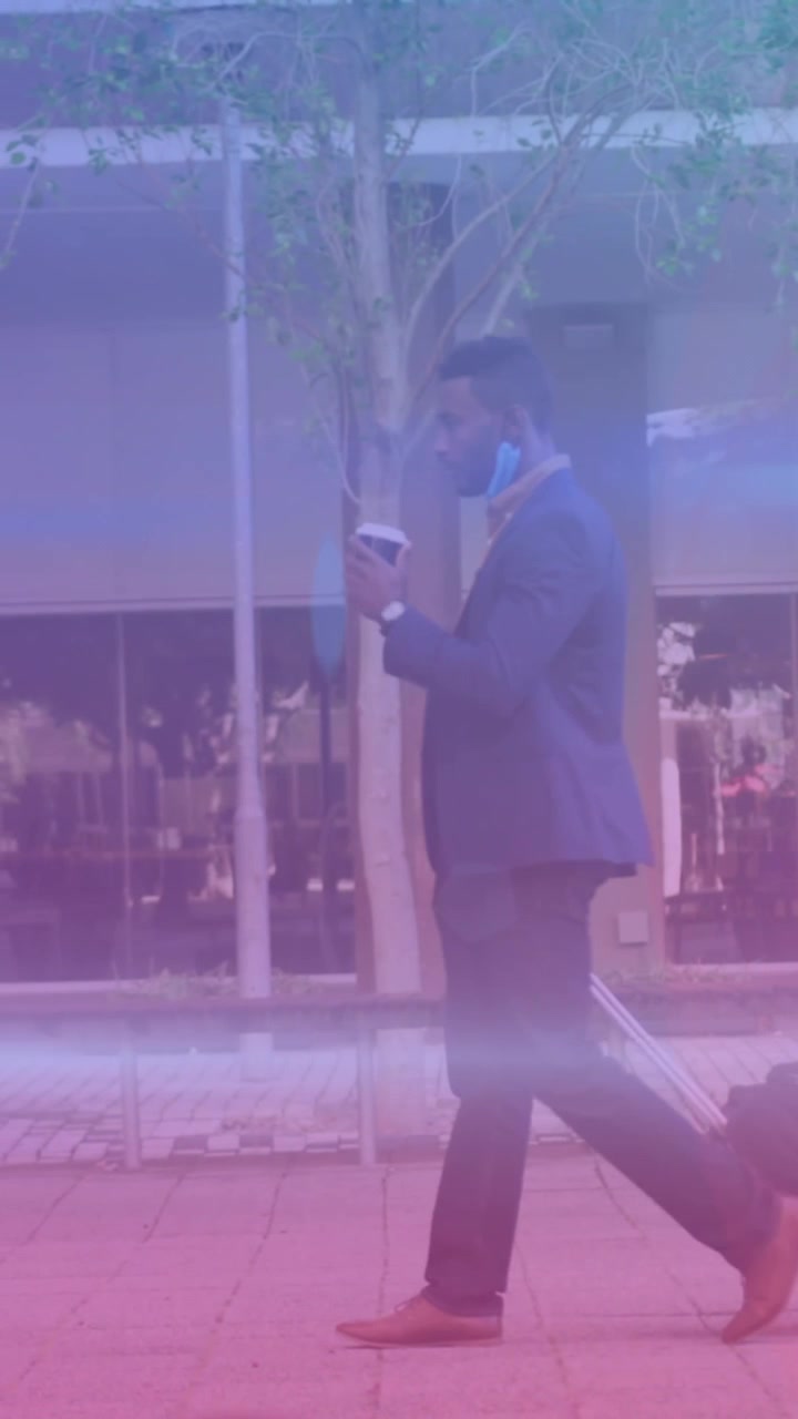 Man with trolley enjoys coffee on tech-driven global business walk.