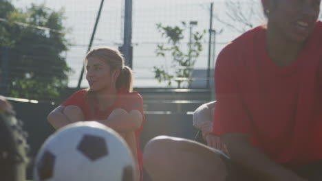 female soccer team chatting during break in warm up training before match