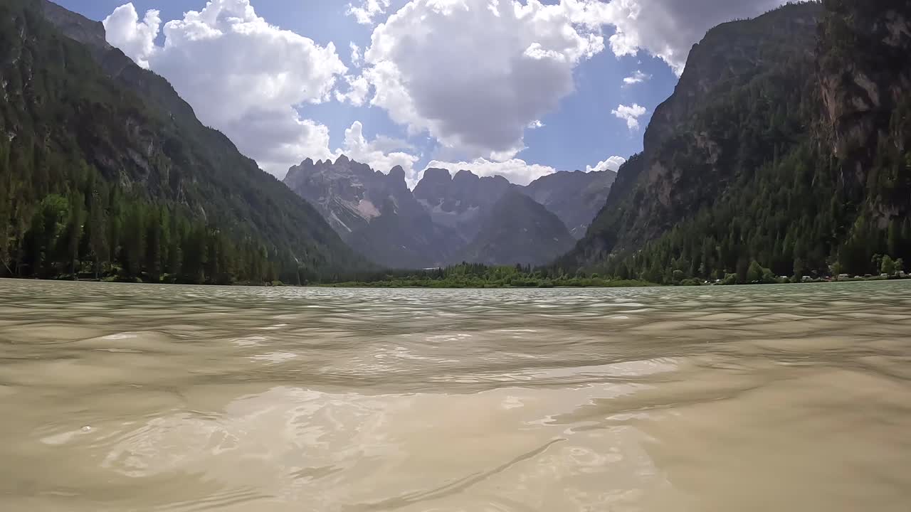 Tourist relaxing in the turquoise water of lago di landro in the dolomites, italy