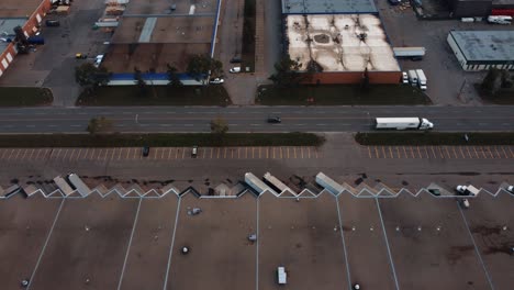 Side-aerial-shot-of-the-semi-truck-among-warehouses