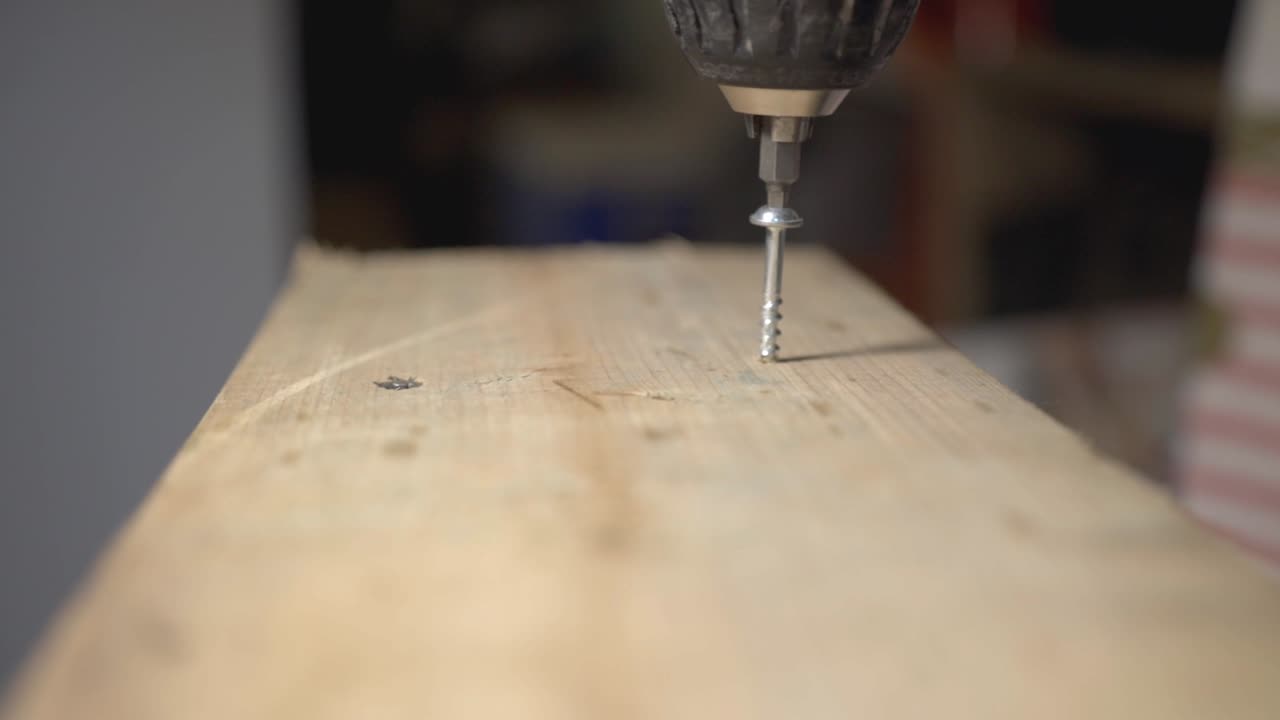 Carpenter Drilling Screw Into The Wooden Lumber. - close up shot