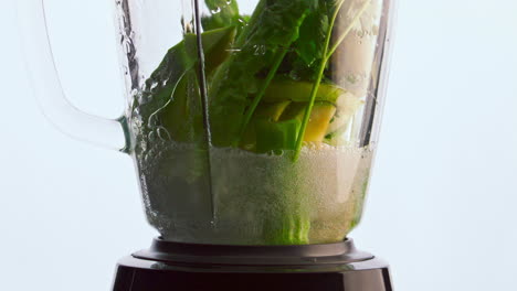 las verduras de la licuadora de primer plano vertieron agua en súper cámara lenta. nutrición saludable.