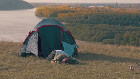 pudgy girl with hard hangover lies at blue tent holding cup