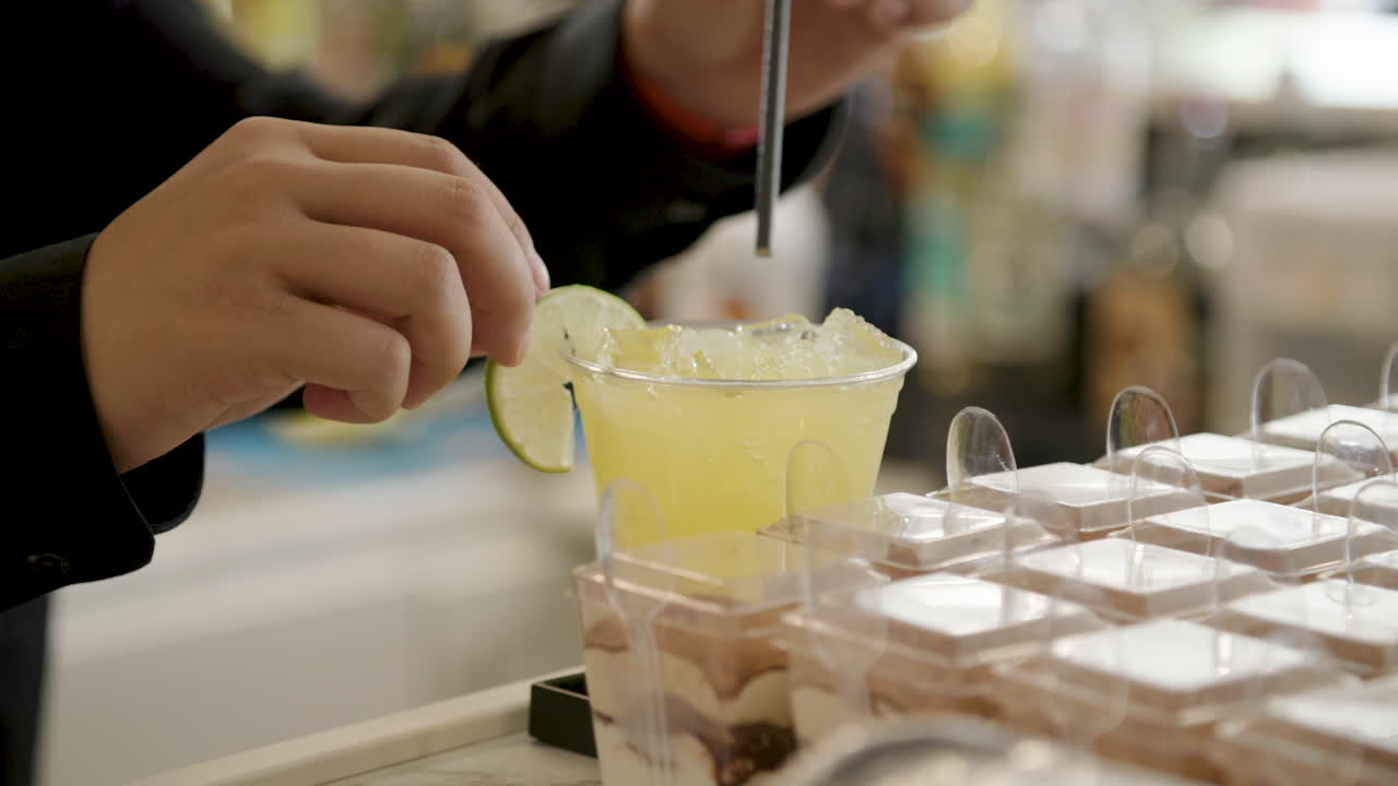 bartender finishing preparing yellow mixed drink at bar