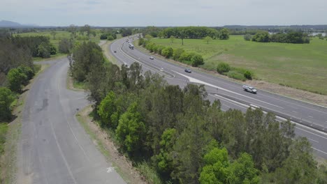 ascenso aéreo en macleay valley way con vehículos circulando en nueva gales del sur, australia