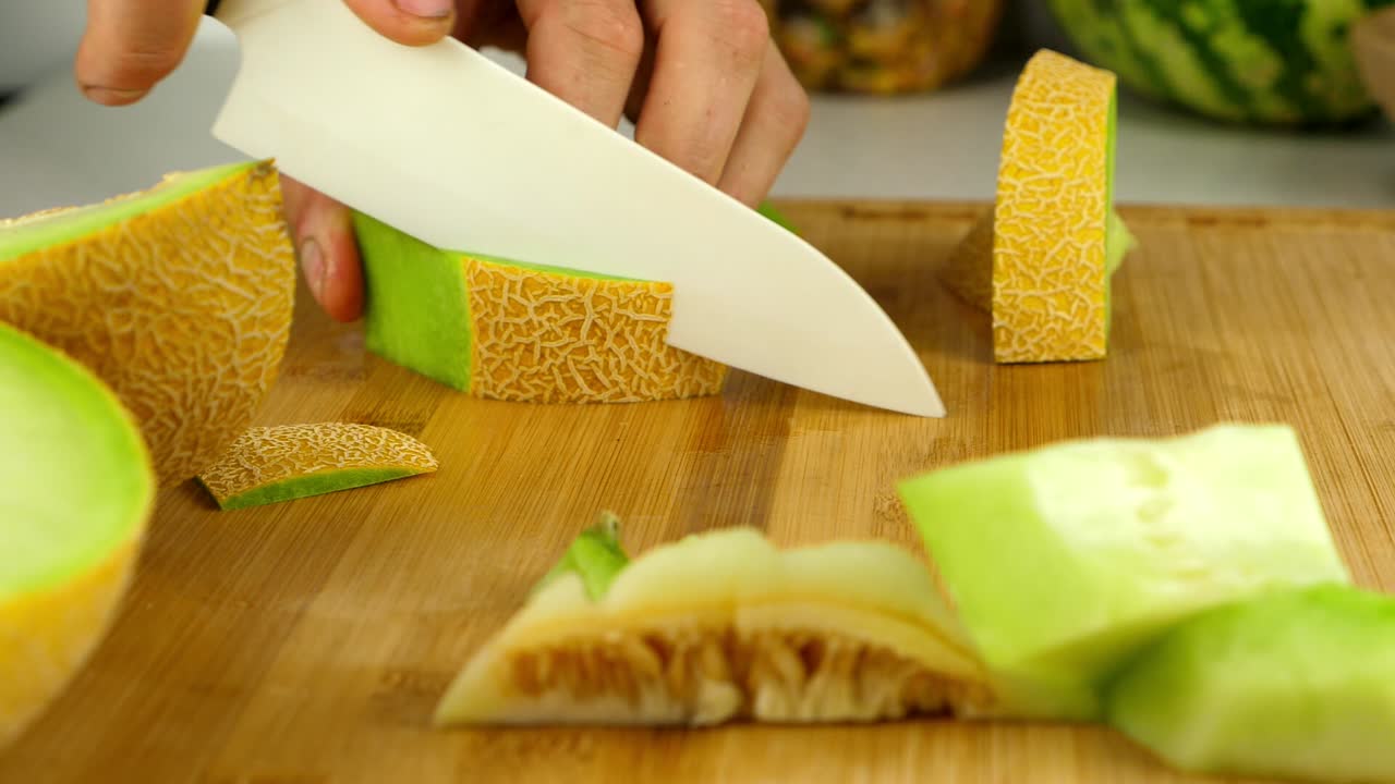 먹을 준비가 된 덩어리로 잘려진 갈리아 멜론 껍질의 슬라이더 샷을 닫습니다.