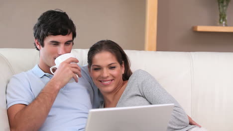 una pareja feliz mirando una computadora portátil