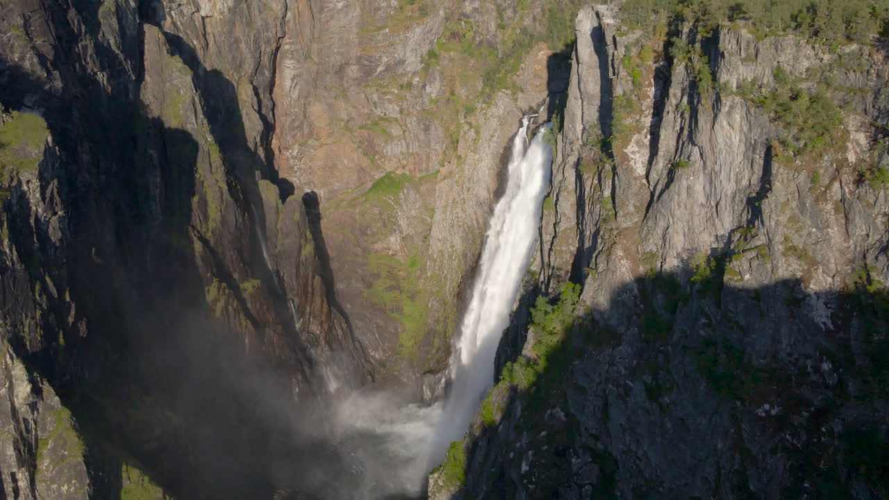 Imposing waterfall plunges down sheer cliff in rugged mountainside