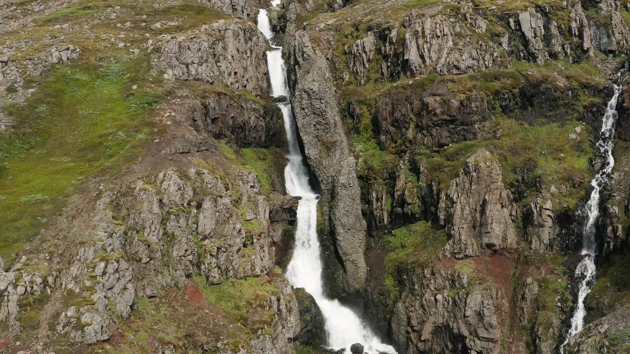 cascada natural con flujo de agua derretida en la montaña rocosa en islandia