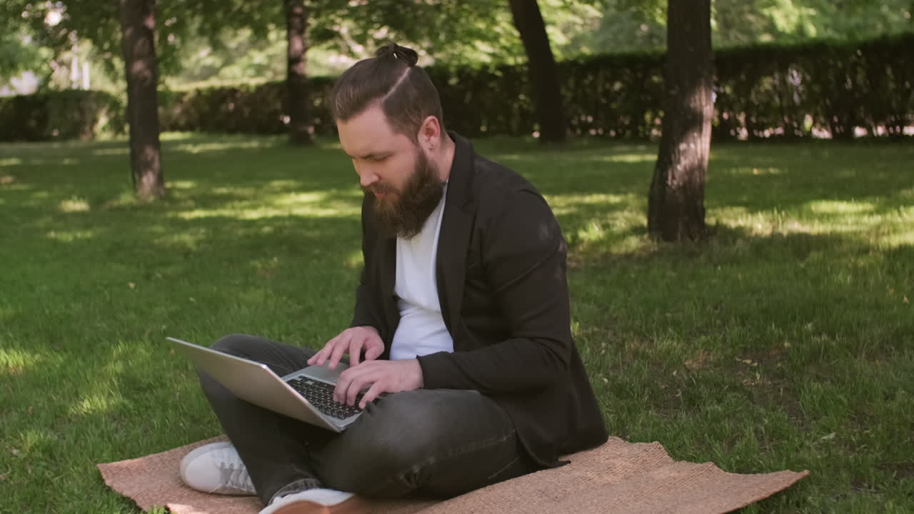 Man Working on Laptop in Park on Summer Day