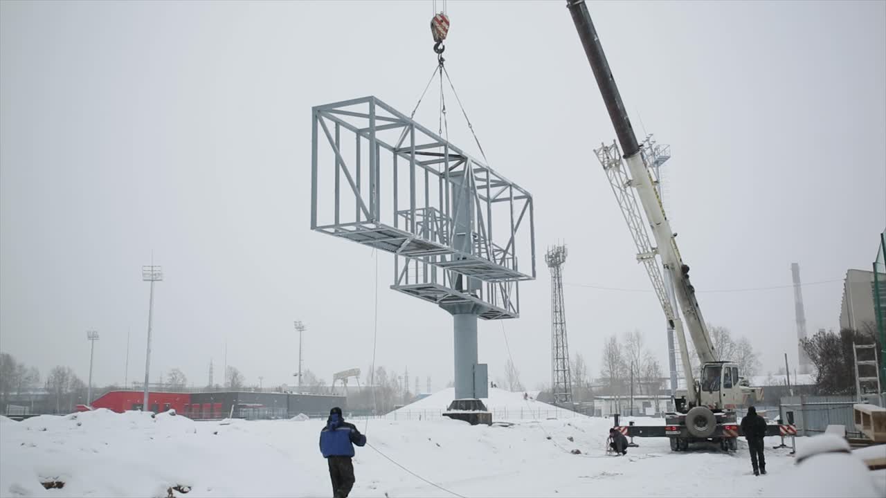 grúa que levanta grandes estructuras metálicas en invierno