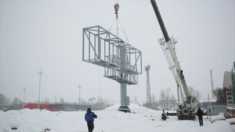 grúa que levanta grandes estructuras metálicas en invierno