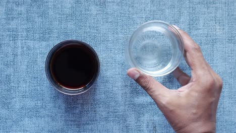 comparing soft drinks with glass of water on table