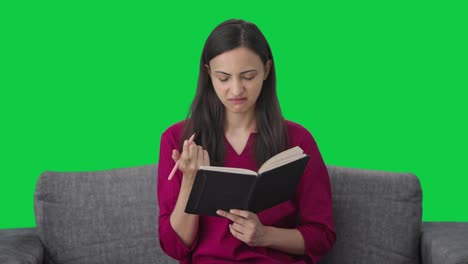 mujer india confundida escribiendo un libro pantalla verde
